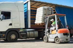 Loading work: Forklift handling cargo and a lorry truck.






