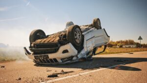  A car overturned on its side, damaged from a collision