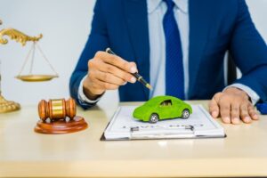 An Asian male lawyer in a formal suit works at his desk, focusing on contracts and legal matters, with a commitment to sustainability and reducing environmental impact.