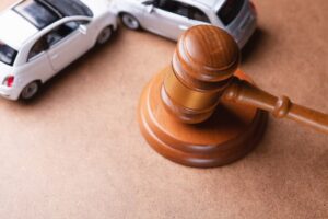 Car model and gavel, representing an accident lawsuit or insurance court case.