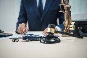 A car and judge's gavel symbolize litigation and legal issues related to the purchase and ownership of personal vehicles.