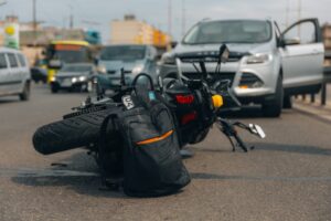 Motorcycle on sidewalk after a serious accident, showing crash aftermath and hazards from a collision with another vehicle.